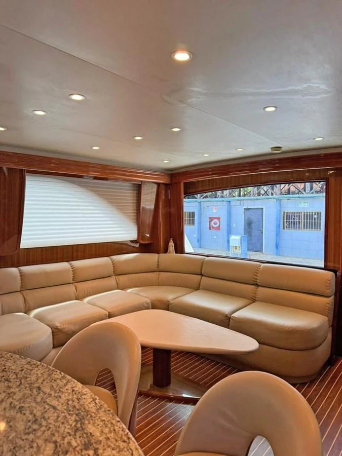 The yacht's salon features a spacious and comfortable seating area with elegant lighting. aboard VIKING 68 CONVERTIBLE Yacht for Sale