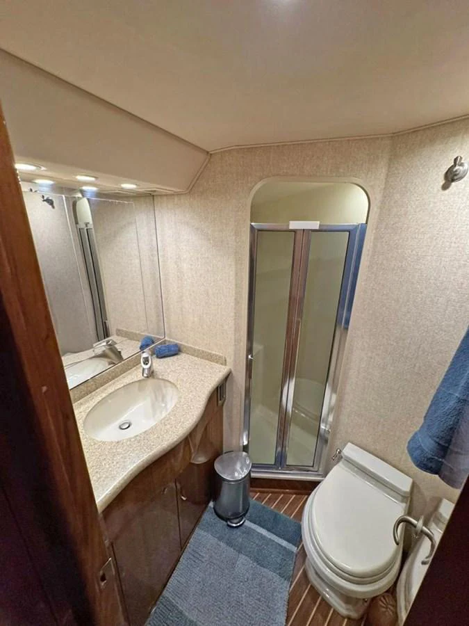 The yacht's head features a compact yet functional design with a shower, sink, and toilet. aboard VIKING 68 CONVERTIBLE Yacht for Sale