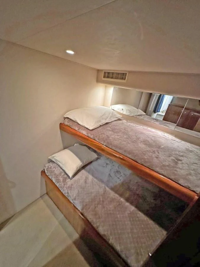 A cozy cabin featuring bunk beds with soft bedding and warm lighting. aboard VIKING 68 CONVERTIBLE Yacht for Sale
