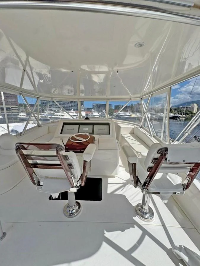 The helm station features modern navigation equipment and comfortable seating with a panoramic view. aboard VIKING 68 CONVERTIBLE Yacht for Sale