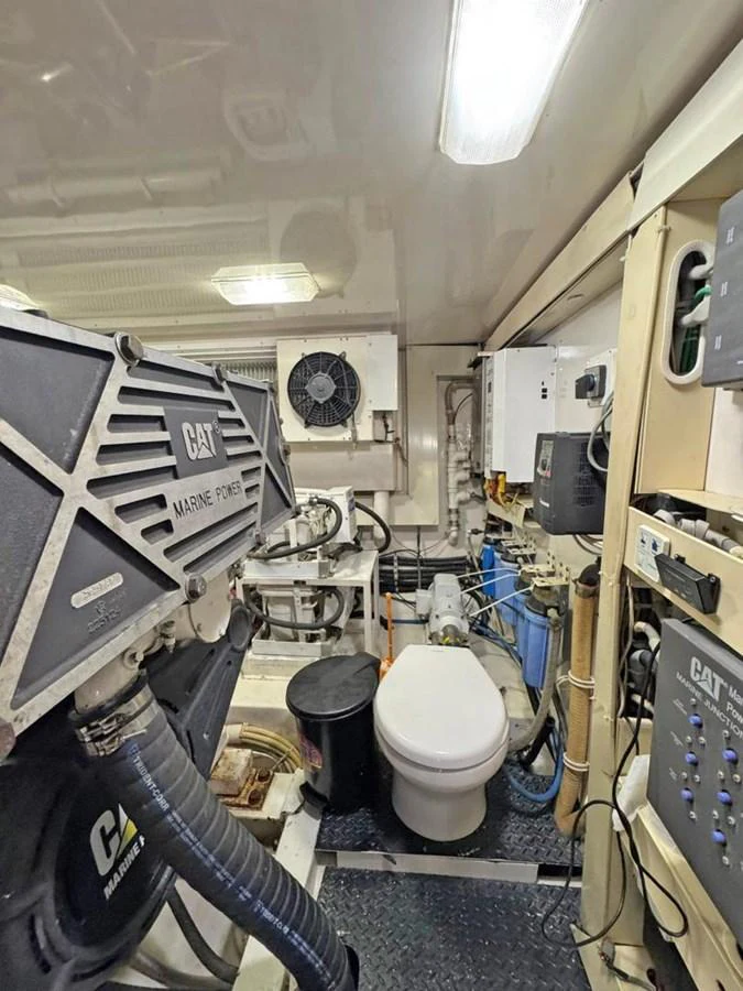 The image showcases the engine room of the yacht, featuring various mechanical components and equipment. aboard VIKING 68 CONVERTIBLE Yacht for Sale