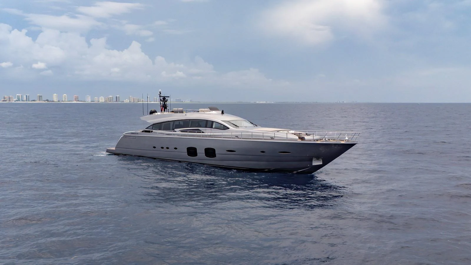 A sleek and modern yacht cruises on calm waters under a partly cloudy sky. aboard ANDIAMO II Yacht for Sale