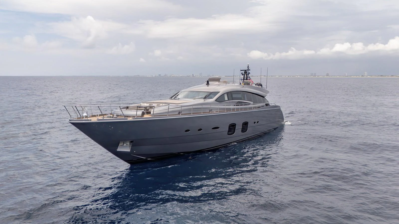 A sleek and modern yacht glides gracefully on the open sea under a partly cloudy sky. aboard ANDIAMO II Yacht for Sale