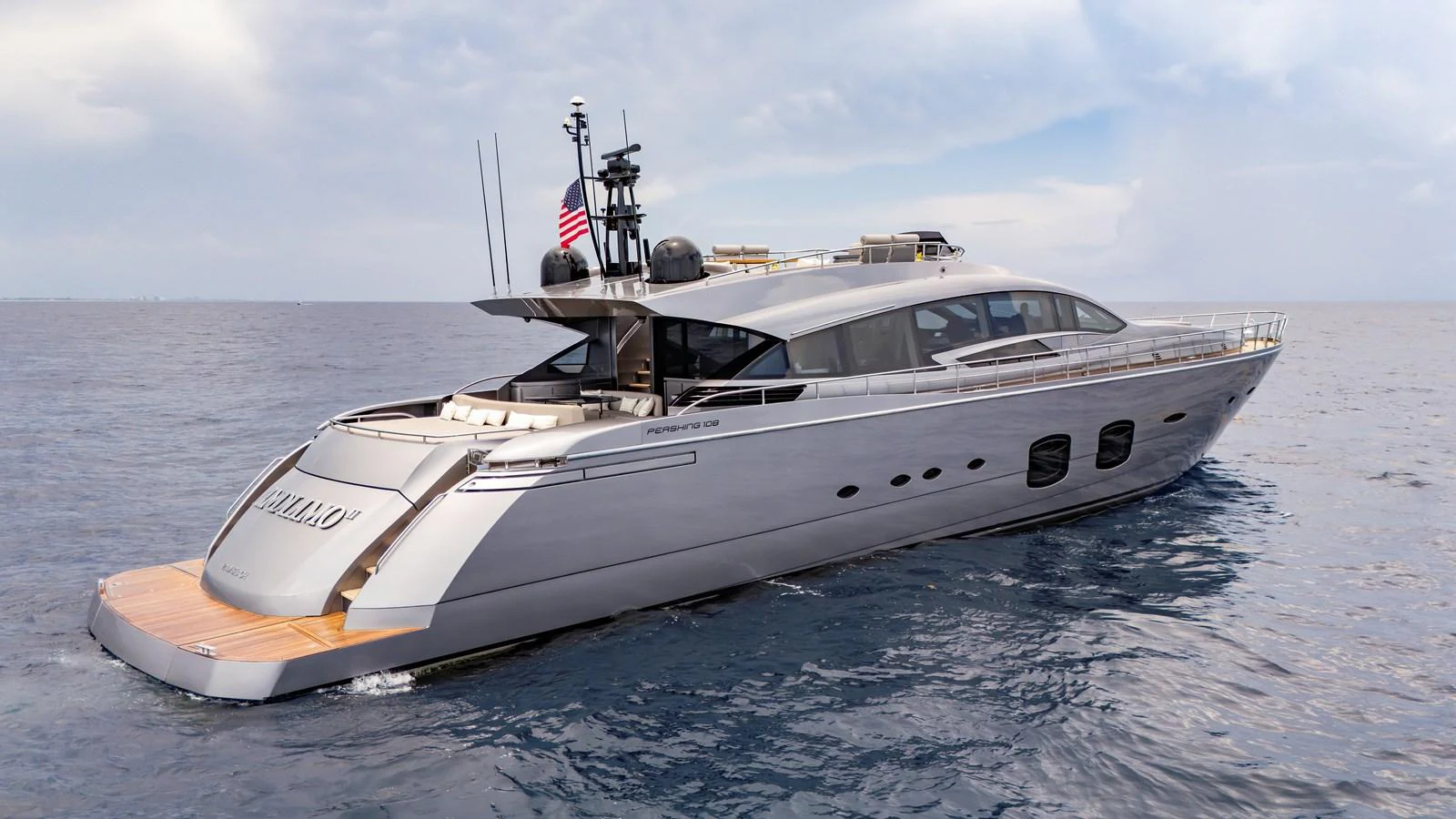 A sleek and modern yacht cruising on calm waters under a partly cloudy sky. aboard ANDIAMO II Yacht for Sale