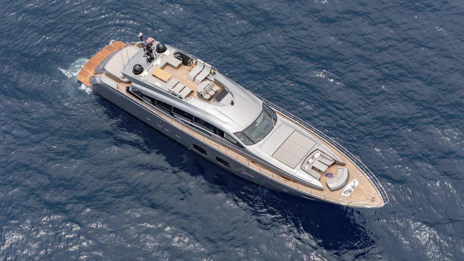 A sleek and modern yacht glides gracefully over the deep blue sea, showcasing its luxurious design and spacious deck areas. aboard ANDIAMO II Yacht for Sale
