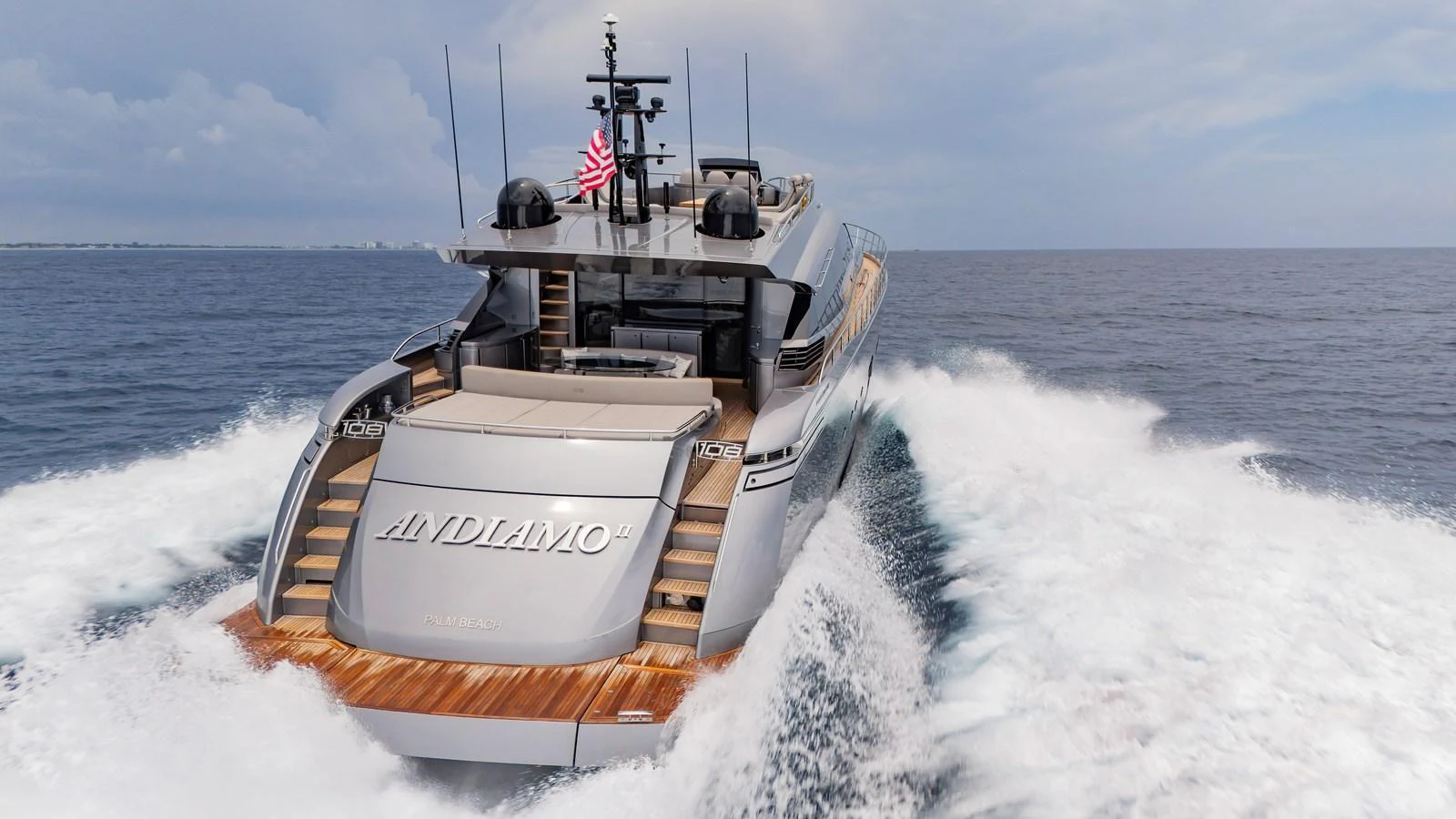 A sleek yacht cruises powerfully through the open sea, showcasing its modern design and luxurious amenities. aboard ANDIAMO II Yacht for Sale