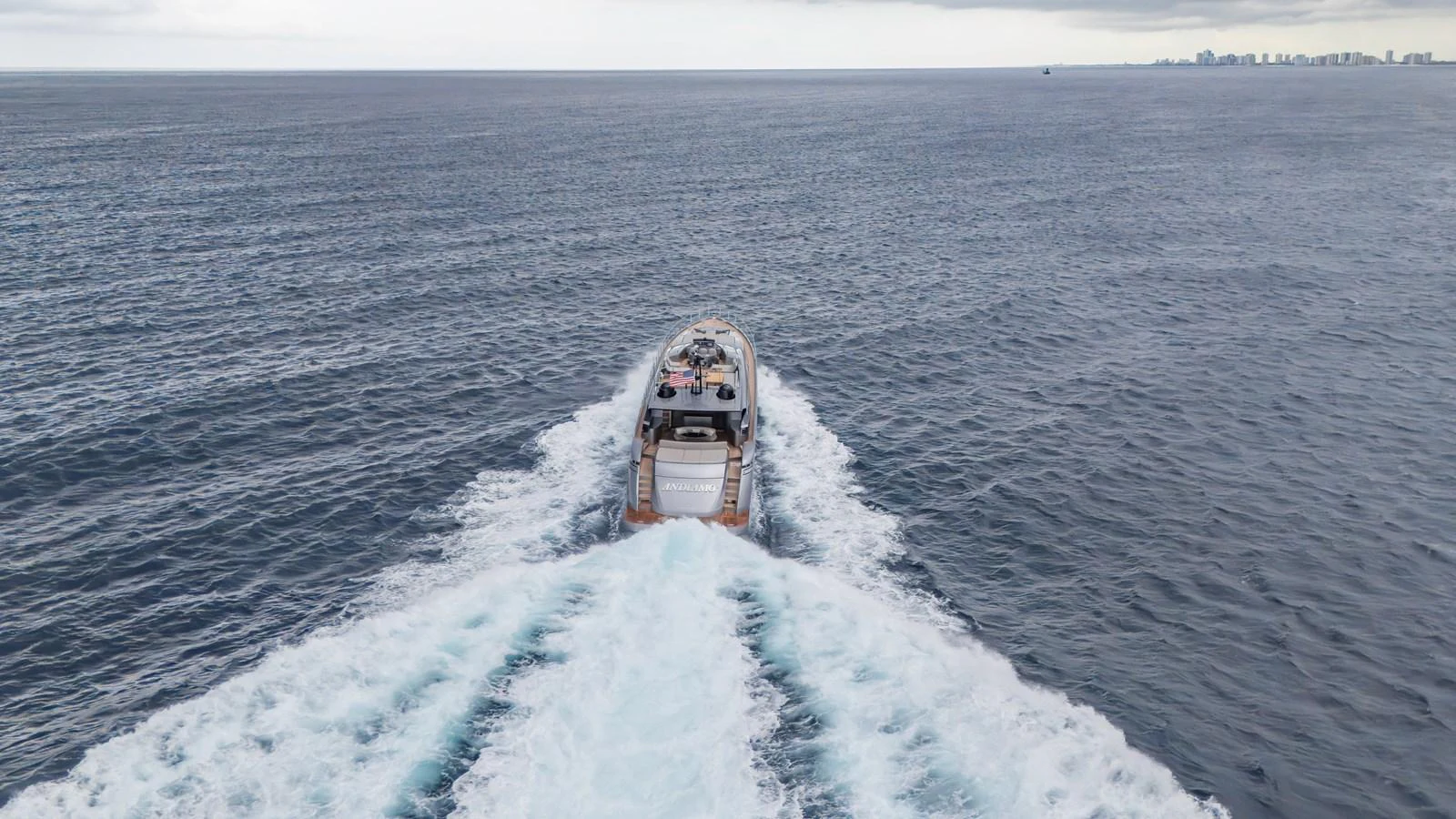 The yacht cruises through open waters, leaving a trail of white foam behind. aboard ANDIAMO II Yacht for Sale