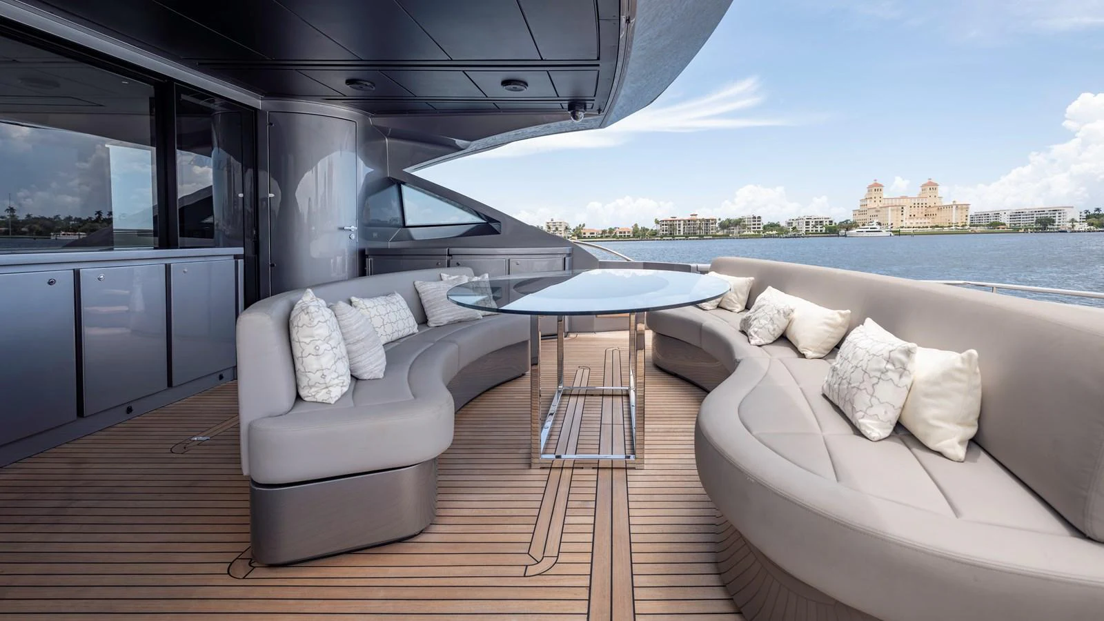 The aft deck features a stylish seating area with a glass-topped table, offering a perfect spot for relaxation and enjoying the view. aboard ANDIAMO II Yacht for Sale