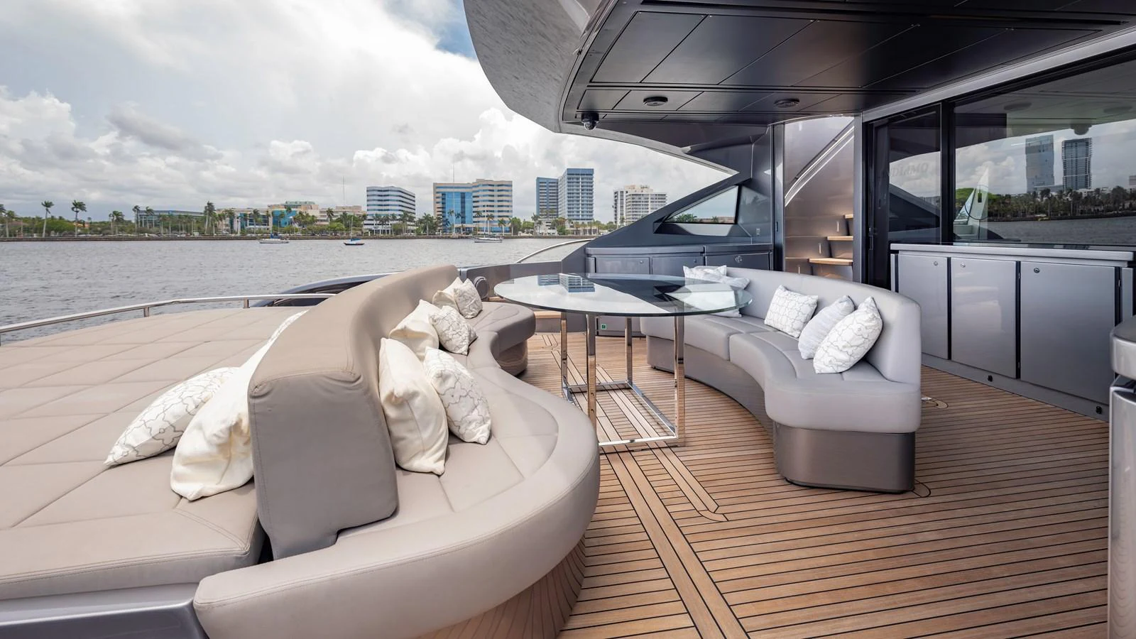 The aft deck features a spacious seating area with plush cushions and a sleek dining table, perfect for outdoor relaxation and dining. aboard ANDIAMO II Yacht for Sale