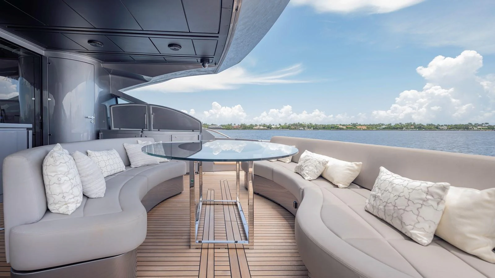 The aft deck features a stylish seating area with a circular glass table, perfect for enjoying the view. aboard ANDIAMO II Yacht for Sale