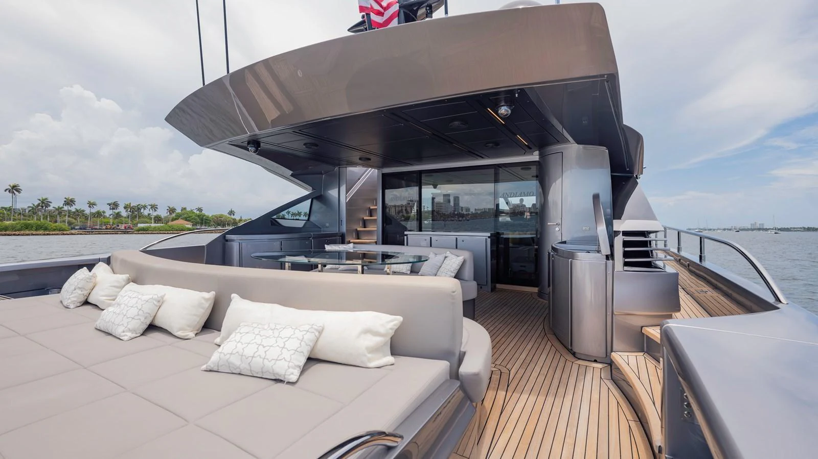 The aft deck features a spacious lounging area with plush seating and a dining table, perfect for outdoor relaxation and entertainment. aboard ANDIAMO II Yacht for Sale