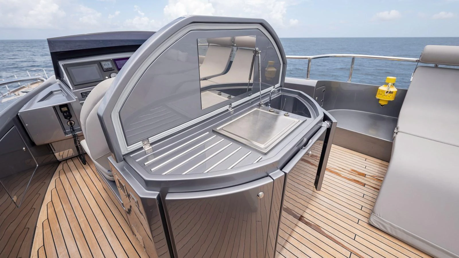 The flybridge features a sleek outdoor kitchen area with a grill and sink, perfect for alfresco dining. aboard ANDIAMO II Yacht for Sale