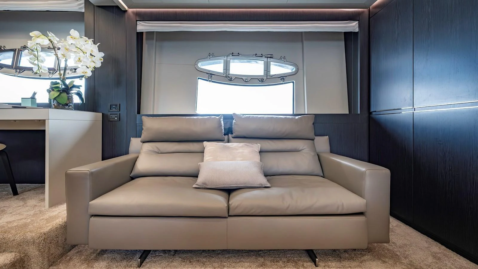 The yacht's salon features a plush leather sofa with a modern design, complemented by elegant decor and soft lighting. aboard ANDIAMO II Yacht for Sale