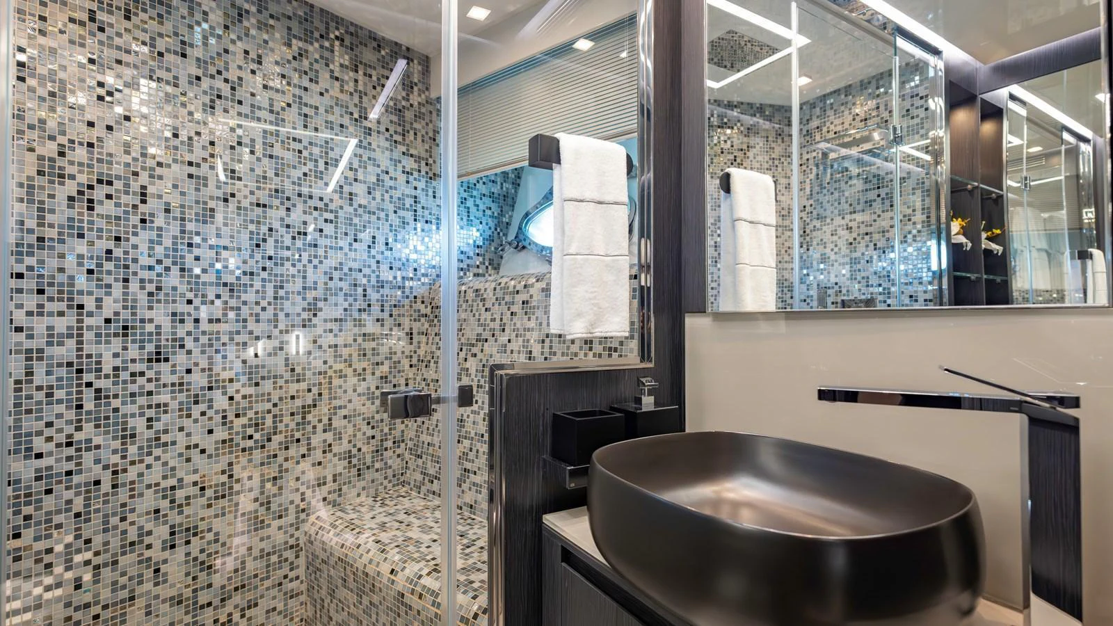 The yacht's bathroom features a modern design with a mosaic-tiled shower and sleek fixtures. aboard ANDIAMO II Yacht for Sale