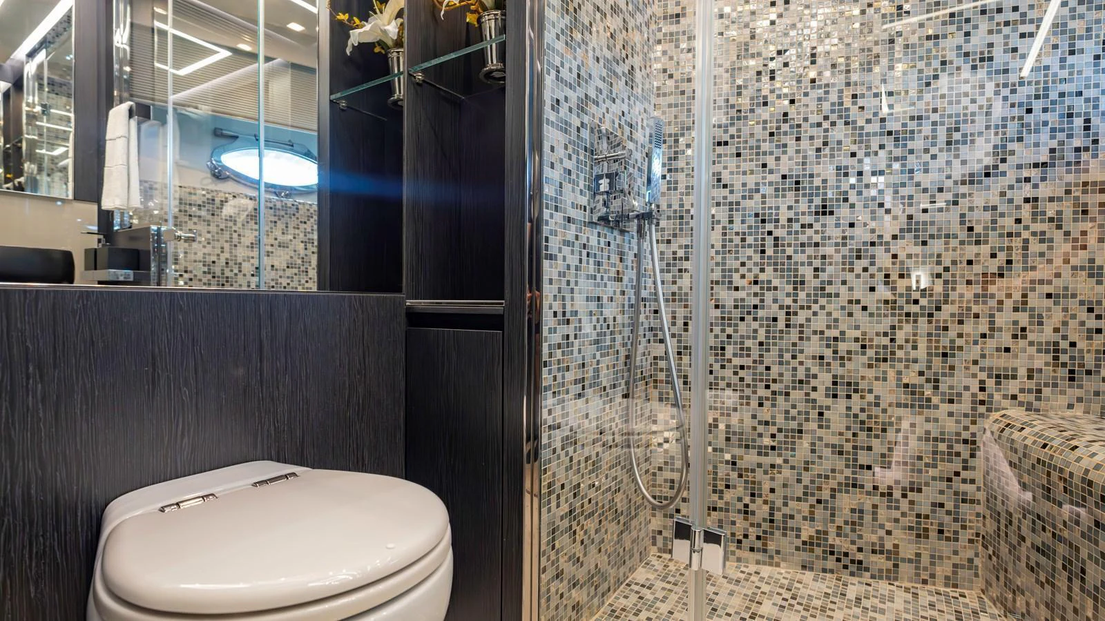 The yacht's bathroom features modern fixtures and a stylish mosaic tile design. aboard ANDIAMO II Yacht for Sale