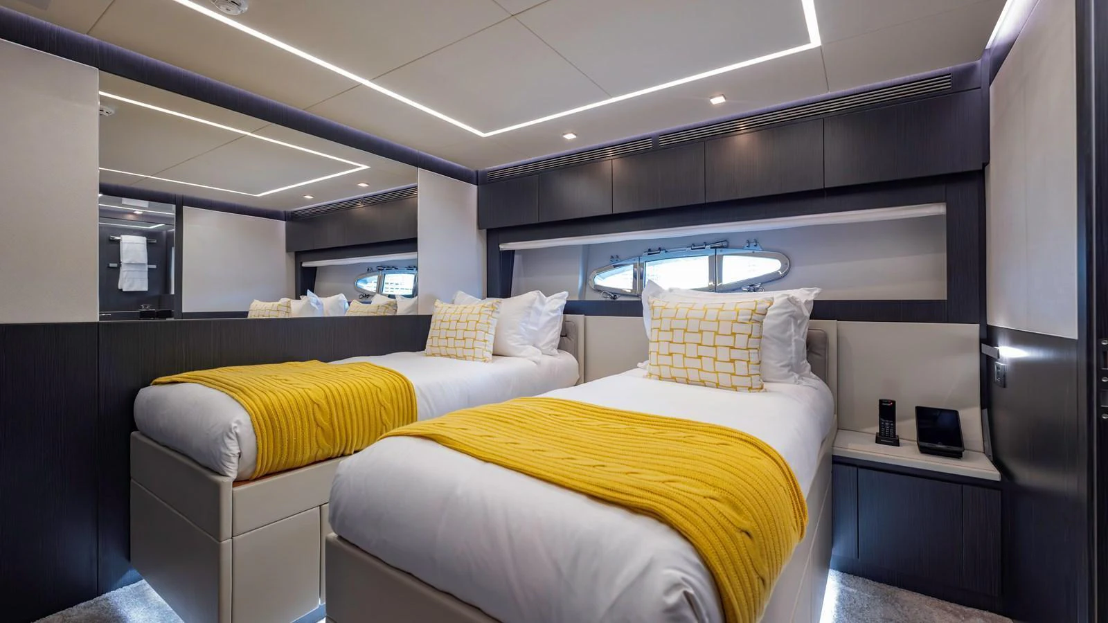 The twin stateroom features modern decor with two single beds and stylish lighting. aboard ANDIAMO II Yacht for Sale