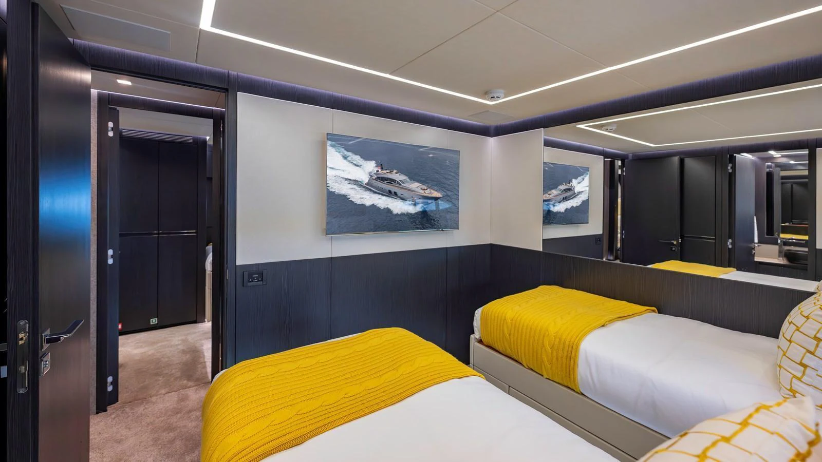 The guest stateroom features twin beds with vibrant yellow accents and modern decor. aboard ANDIAMO II Yacht for Sale