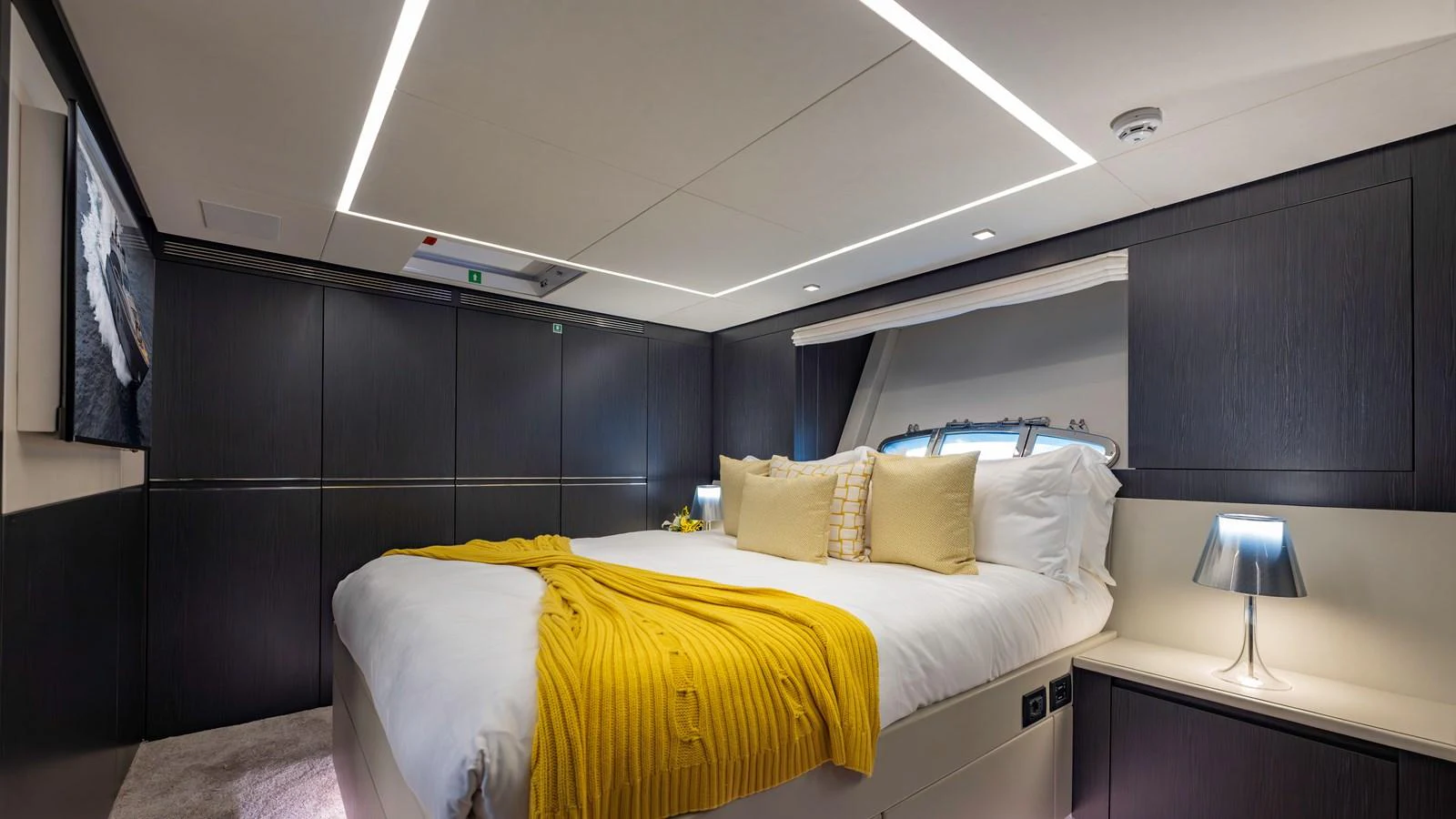The stateroom features a luxurious bed with modern lighting and elegant decor. aboard ANDIAMO II Yacht for Sale