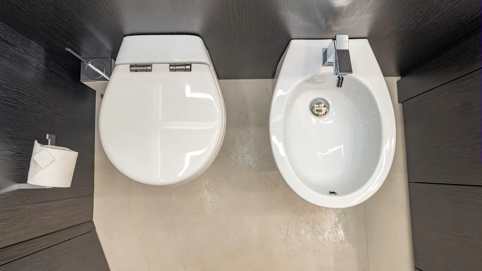 A sleek and modern yacht bathroom featuring a toilet and bidet with contemporary fixtures. aboard ANDIAMO II Yacht for Sale