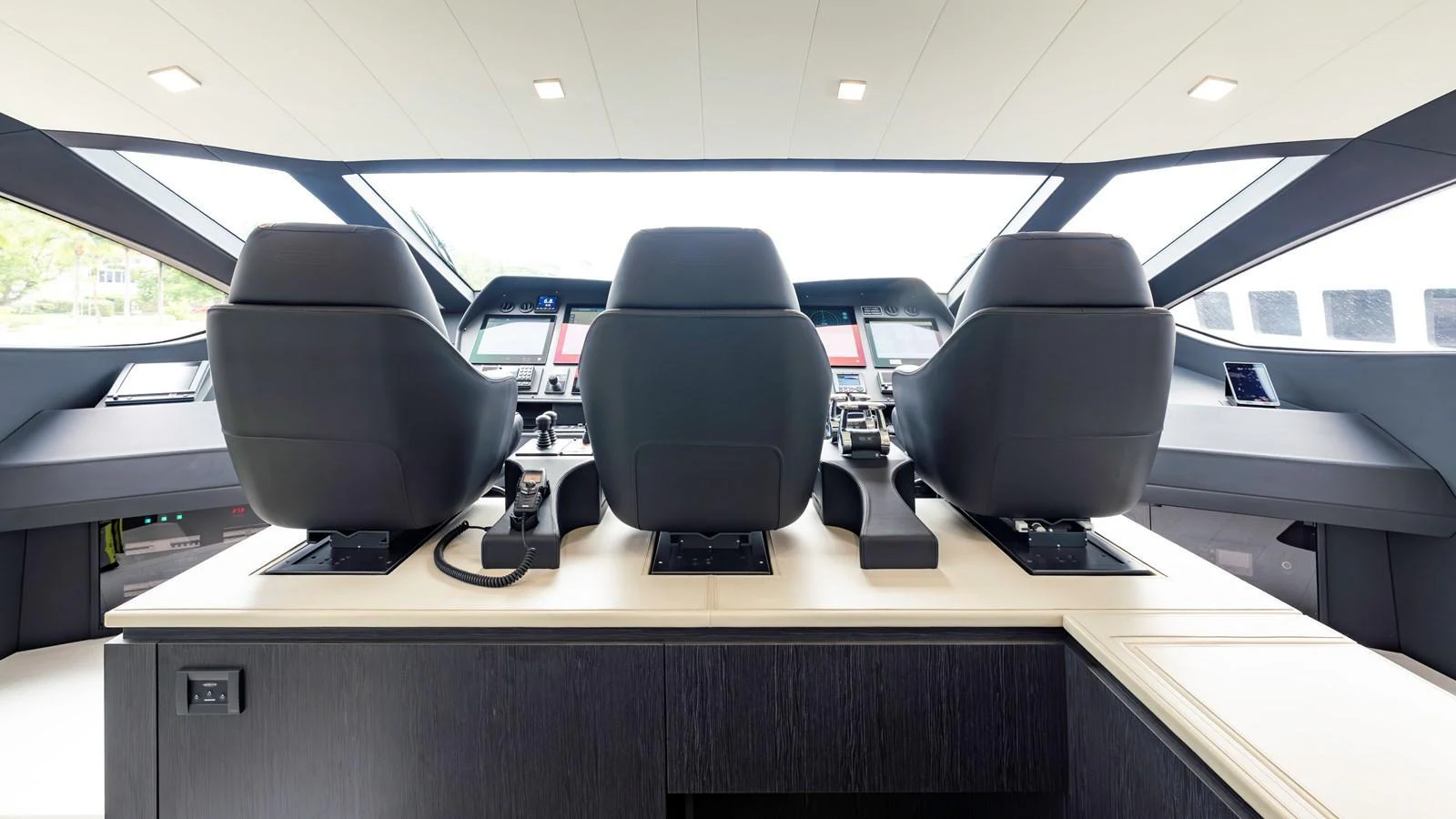 The helm station features three luxurious captain's chairs with a panoramic view of the surroundings. aboard ANDIAMO II Yacht for Sale