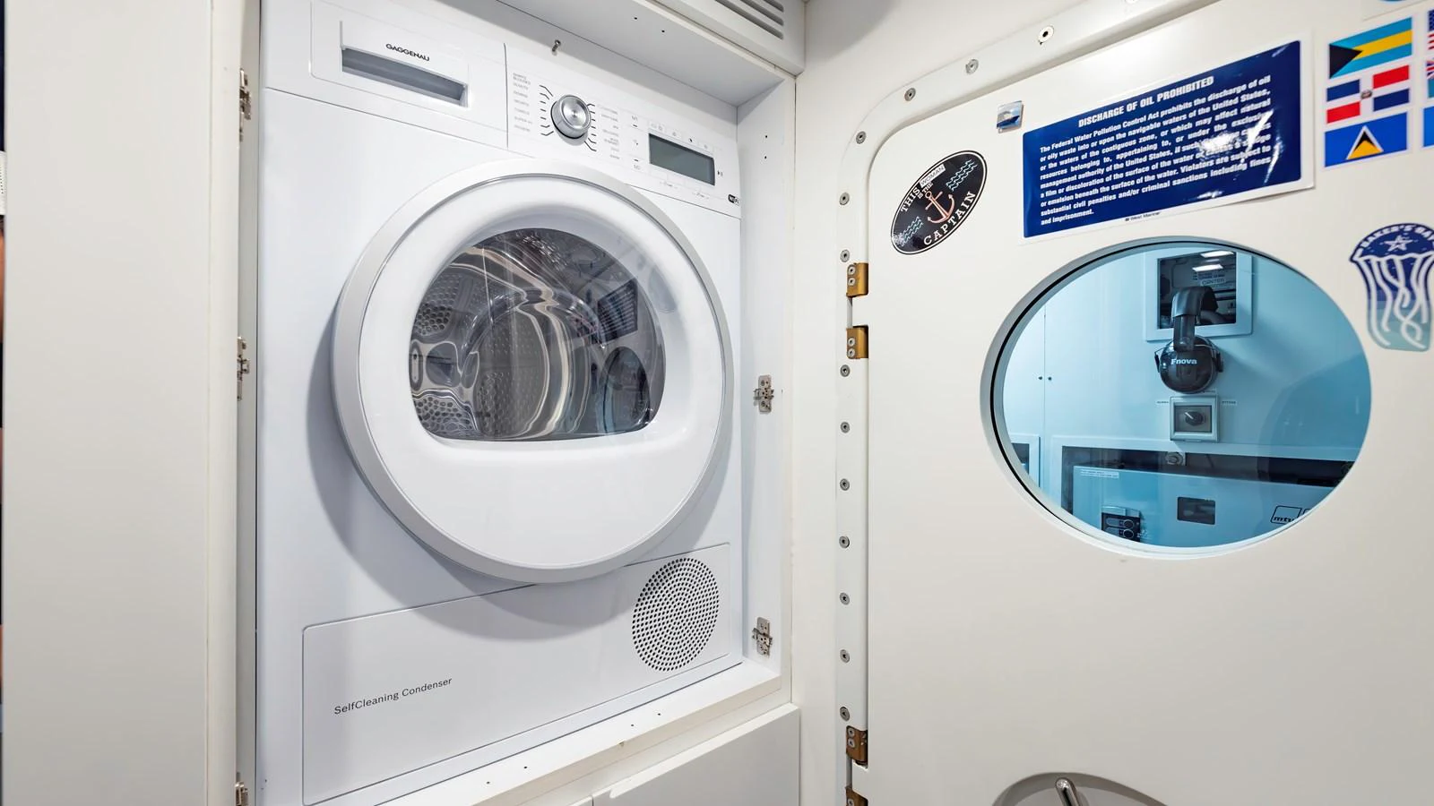 The image showcases a laundry area with a modern washing machine and a door with porthole windows. aboard ANDIAMO II Yacht for Sale