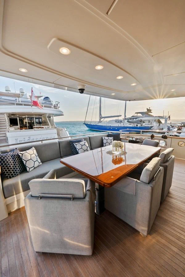a table and chairs in a room with a boat in the background aboard FONTANA Yacht for Sale