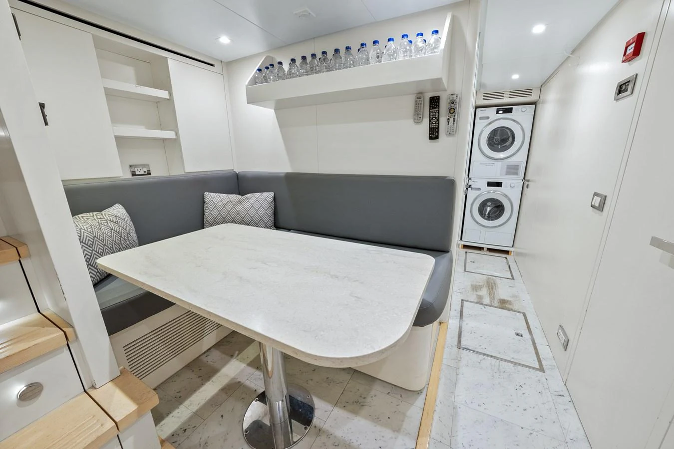 a white kitchen with a black couch aboard FONTANA Yacht for Sale