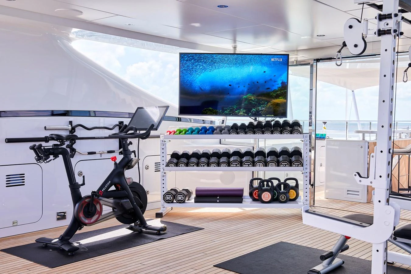 The yacht features a well-equipped gym with modern fitness equipment and a large TV screen. aboard ARKADIA Yacht for Sale