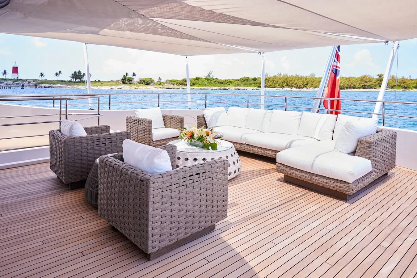 The aft deck features a luxurious seating area with wicker furniture and a stunning view of the water. aboard ARKADIA Yacht for Sale