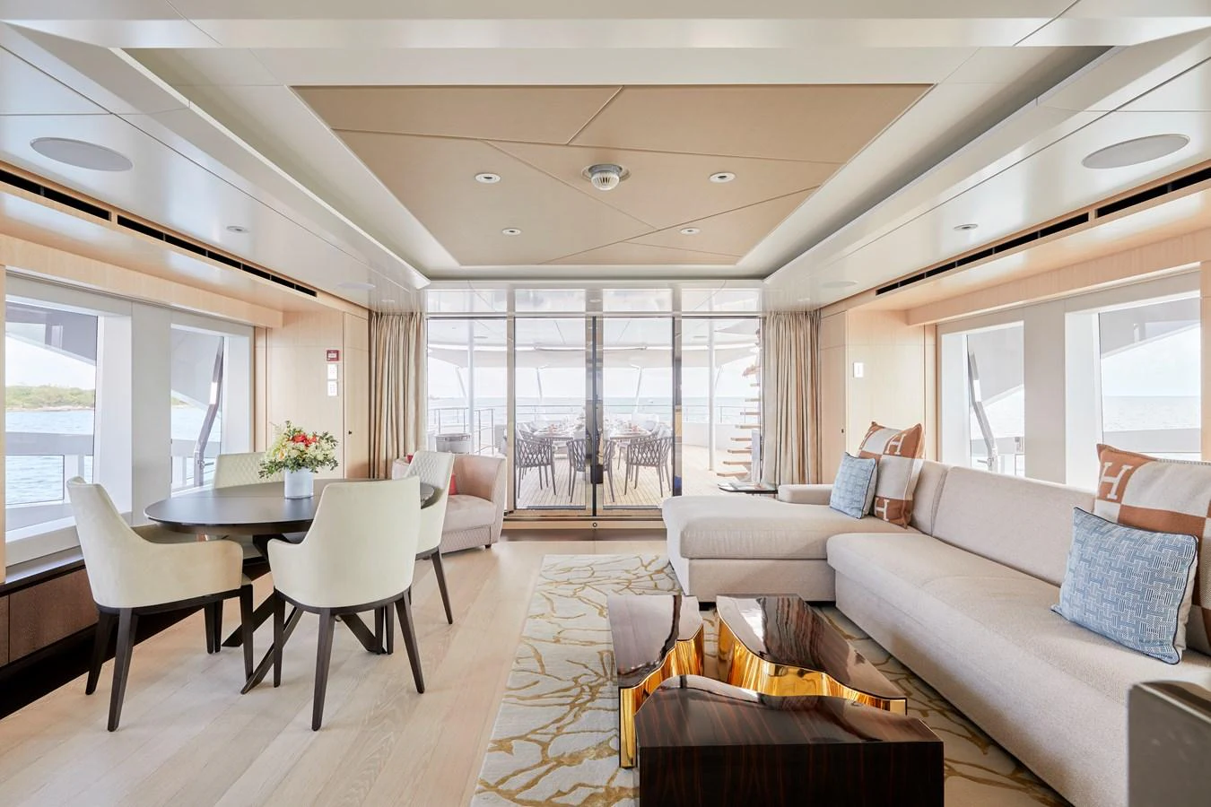 The yacht's salon features elegant seating, a dining area, and large windows offering stunning views. aboard ARKADIA Yacht for Sale