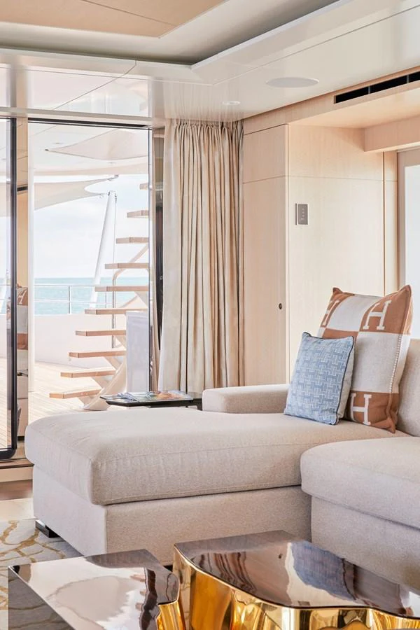 The salon features a luxurious seating area with a view of the deck and ocean beyond. aboard ARKADIA Yacht for Sale