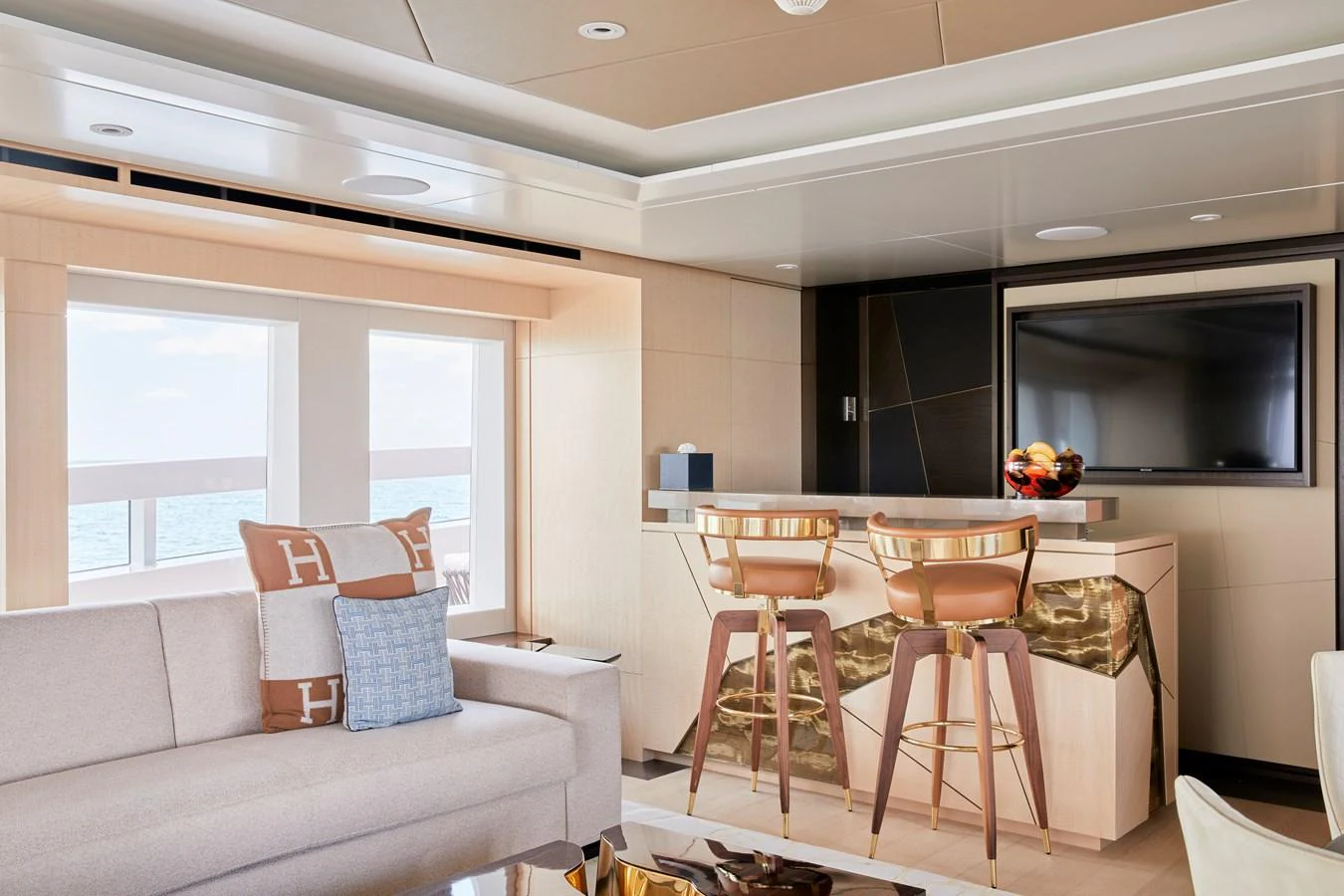 The yacht's salon features a cozy seating area with a modern bar and large windows offering ocean views. aboard ARKADIA Yacht for Sale