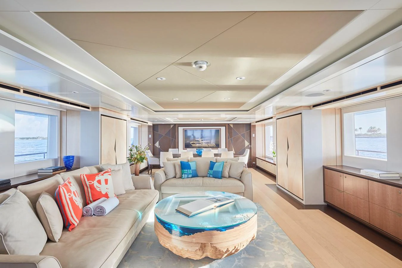 The yacht's salon features luxurious seating and a stylish coffee table with a view of the sea through large windows. aboard ARKADIA Yacht for Sale