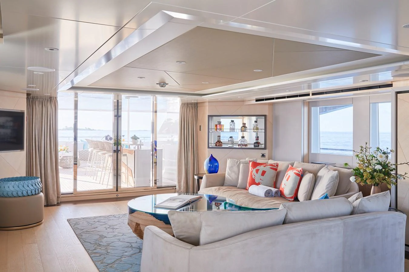 The salon offers a spacious and elegant lounging area with a view of the ocean through large windows. aboard ARKADIA Yacht for Sale