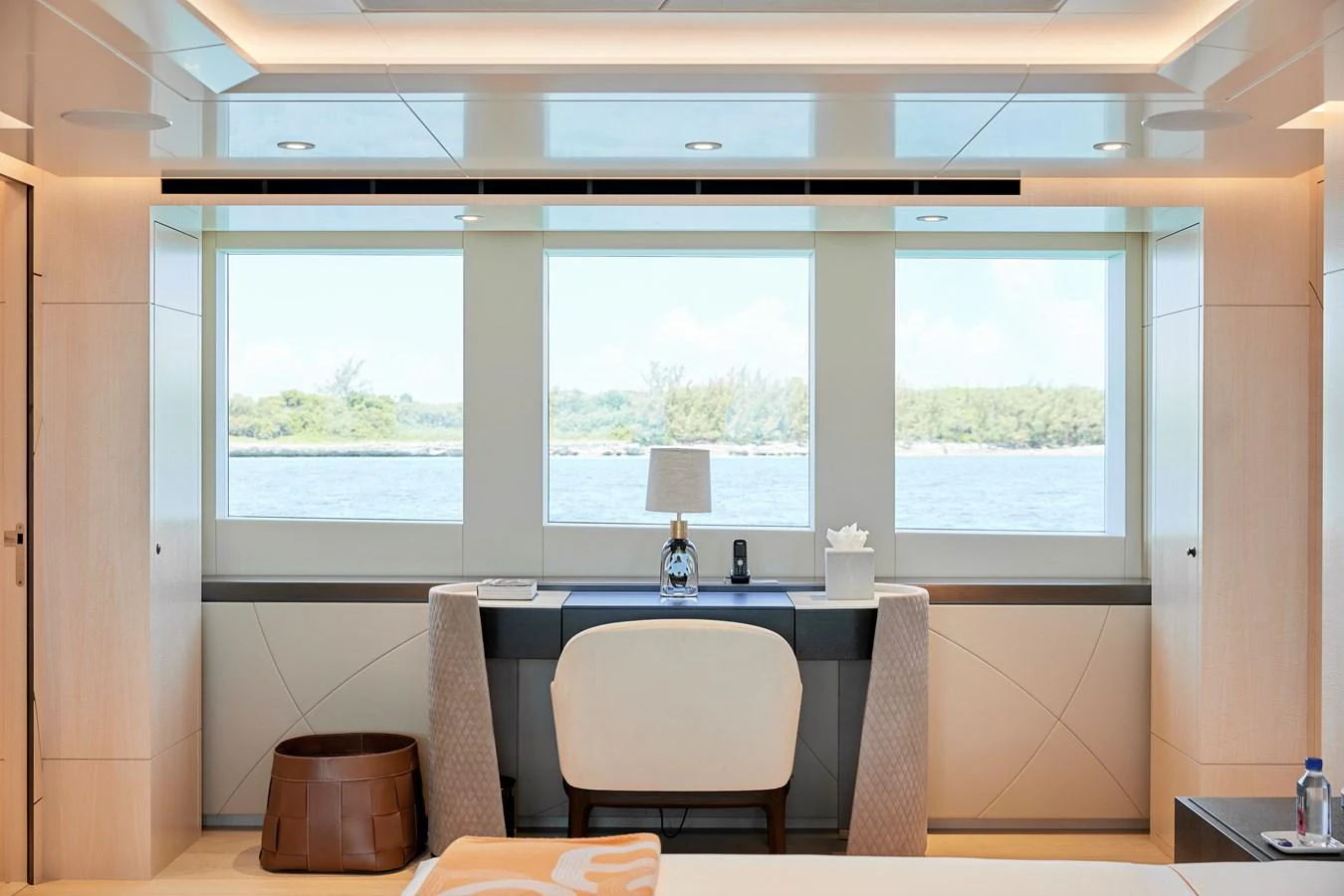A serene stateroom with a desk and large windows offering a beautiful view of the water. aboard ARKADIA Yacht for Sale