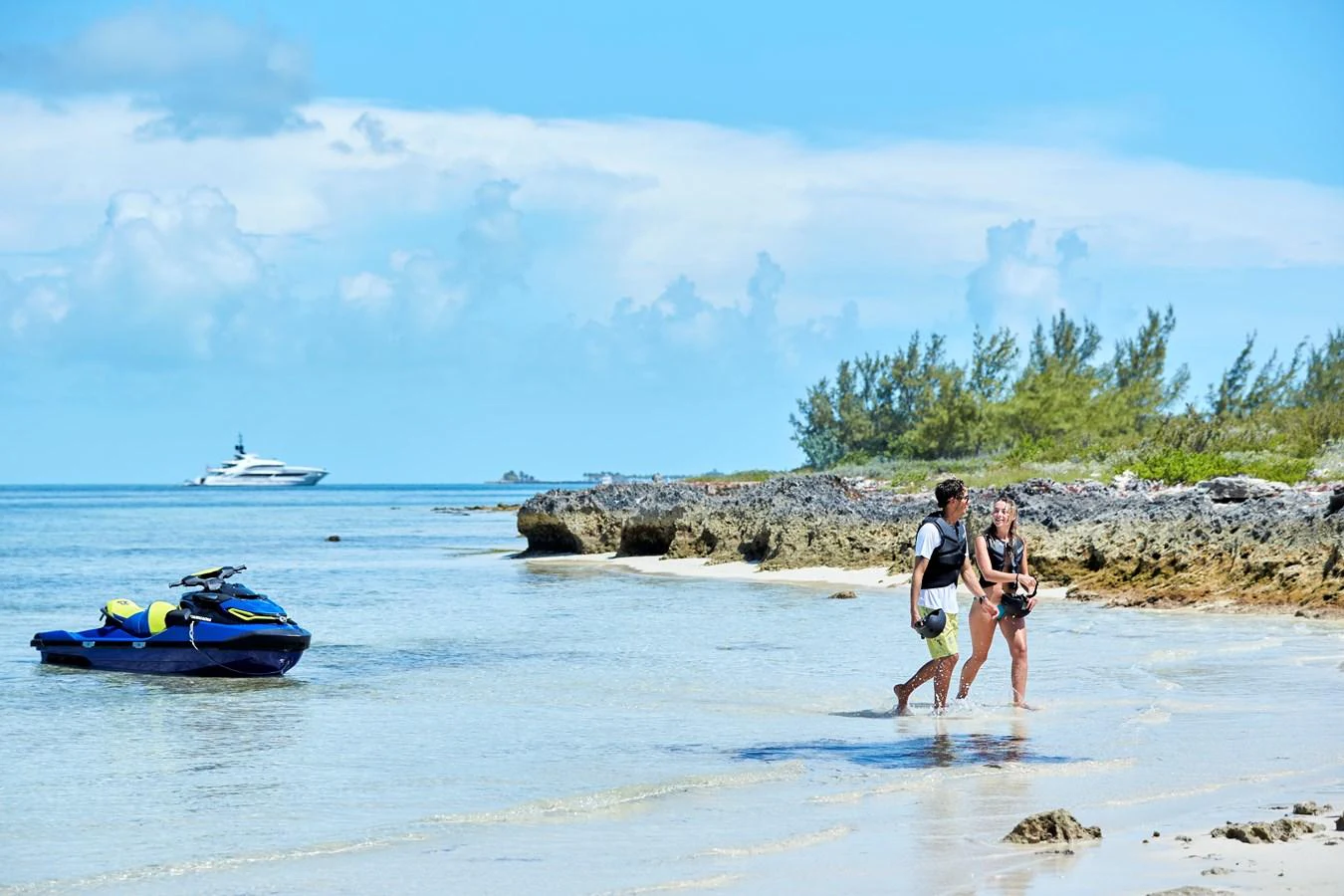 A luxurious yacht is anchored off a picturesque beach with a couple enjoying a stroll along the shore. aboard ARKADIA Yacht for Sale