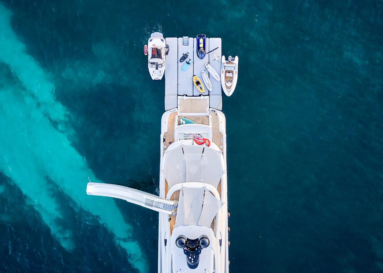 Aerial view of a yacht's aft deck with various water toys and a slide extending into the sea. aboard ARKADIA Yacht for Sale