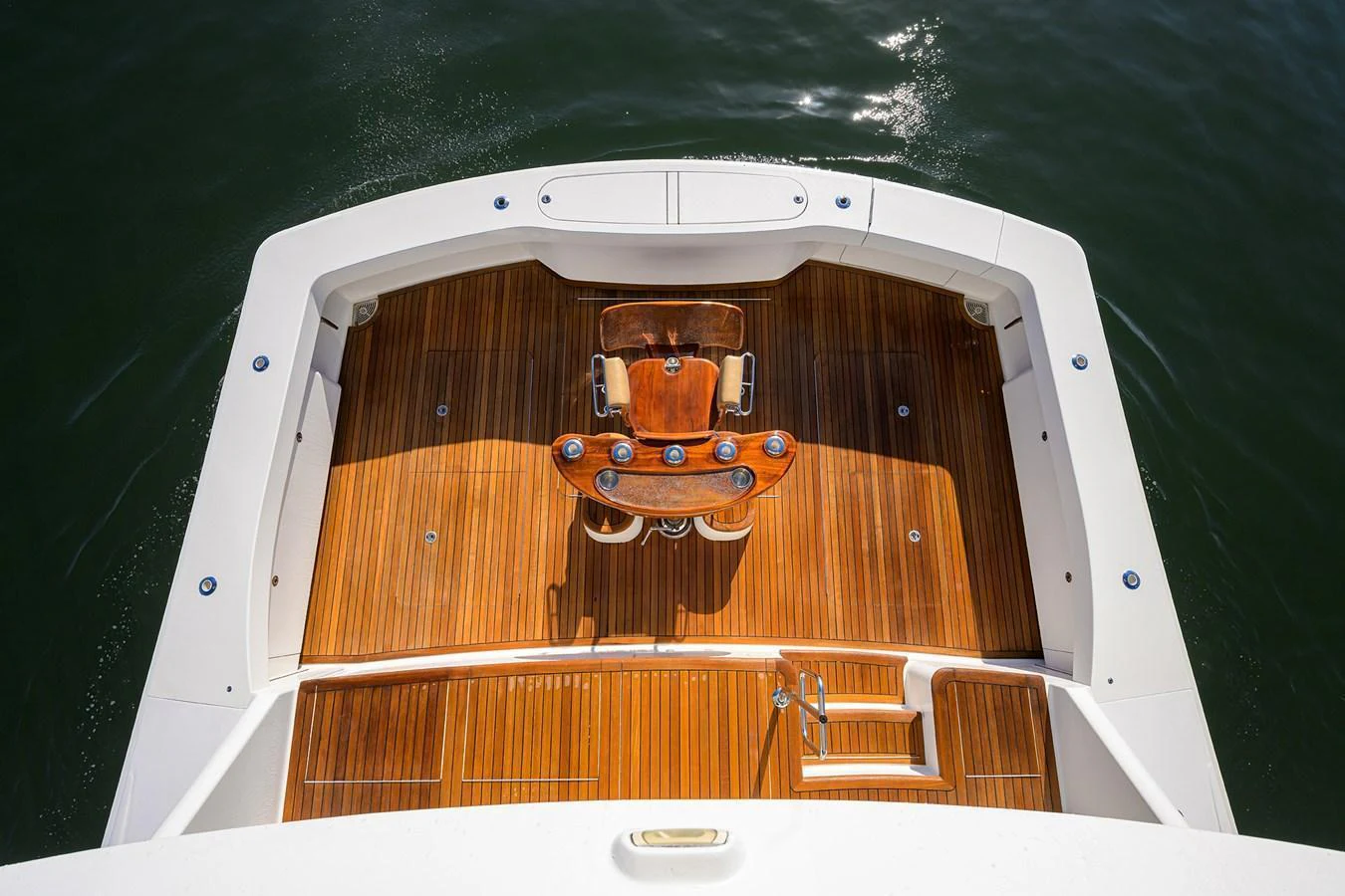 The yacht's aft deck features a beautifully crafted wooden fishing chair and ample space for relaxation. aboard WASABI Yacht for Sale