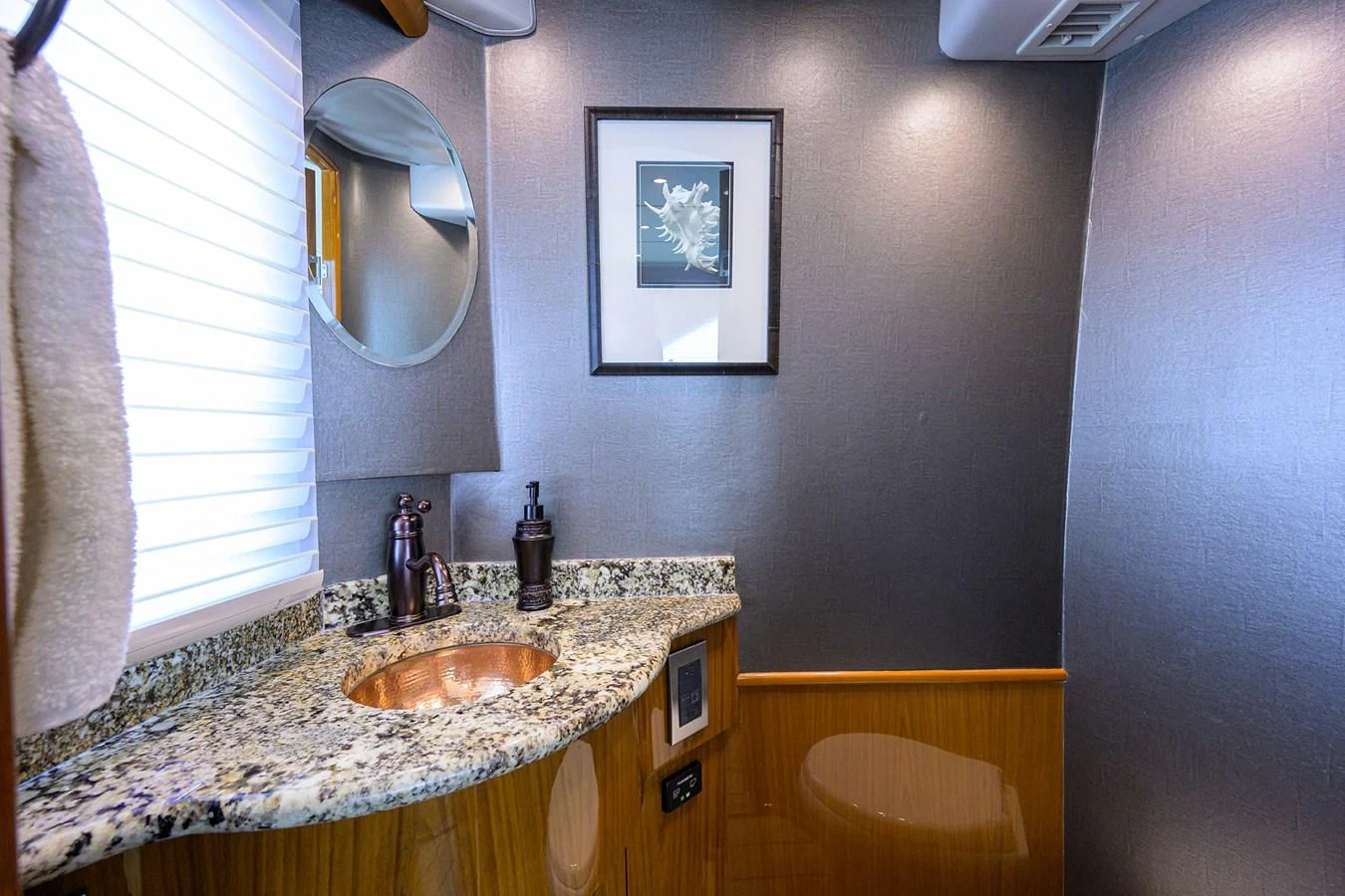 The yacht's bathroom features a sleek design with a granite countertop and modern fixtures. aboard WASABI Yacht for Sale
