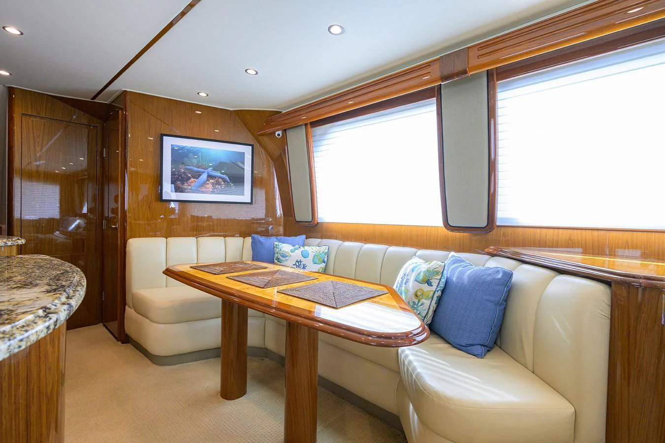 The yacht's dining area features a cozy seating arrangement with a polished wooden table and large windows for natural light. aboard WASABI Yacht for Sale