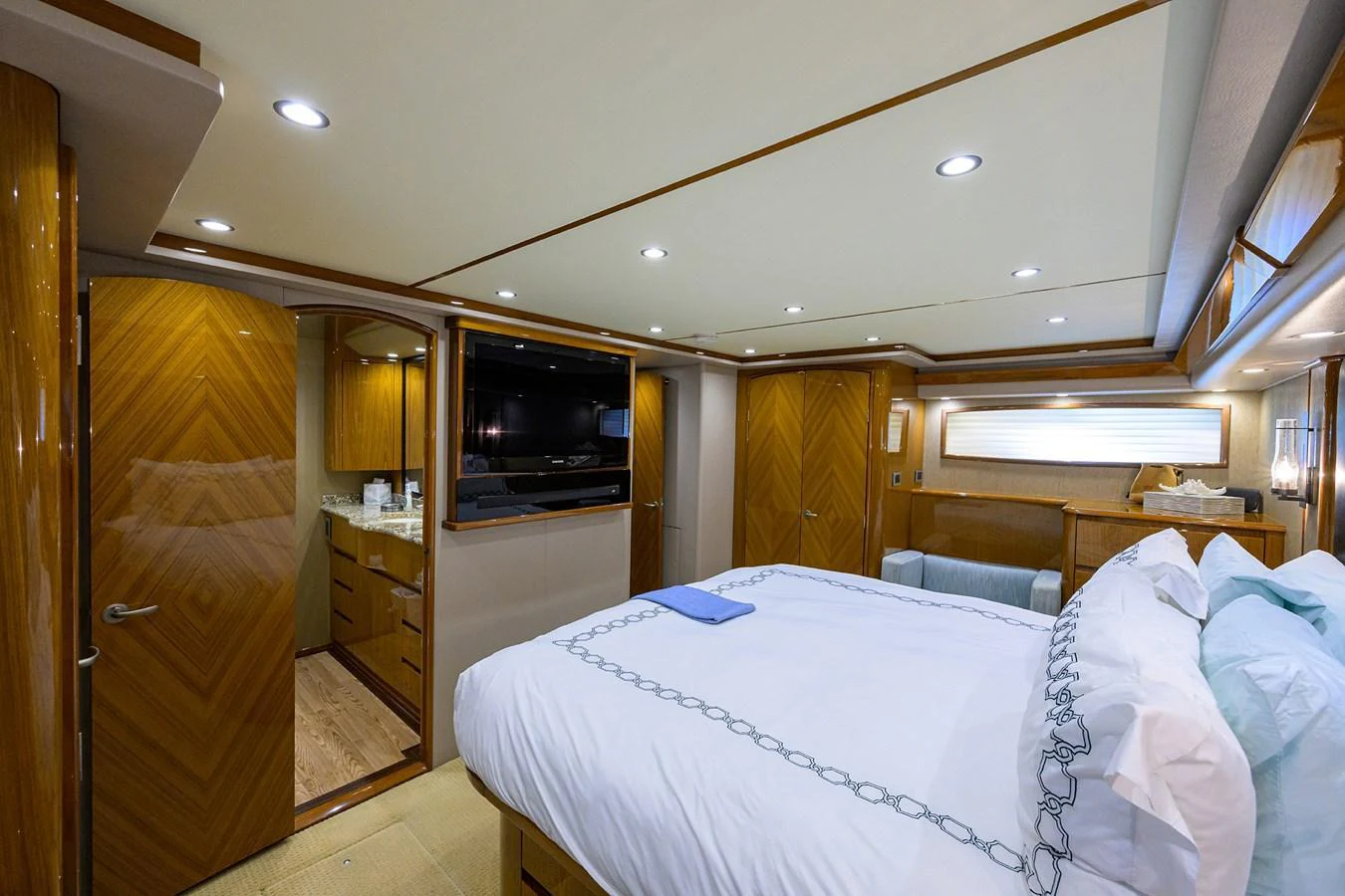 The stateroom features a plush bed, elegant wood finishes, and modern lighting for a luxurious stay. aboard WASABI Yacht for Sale