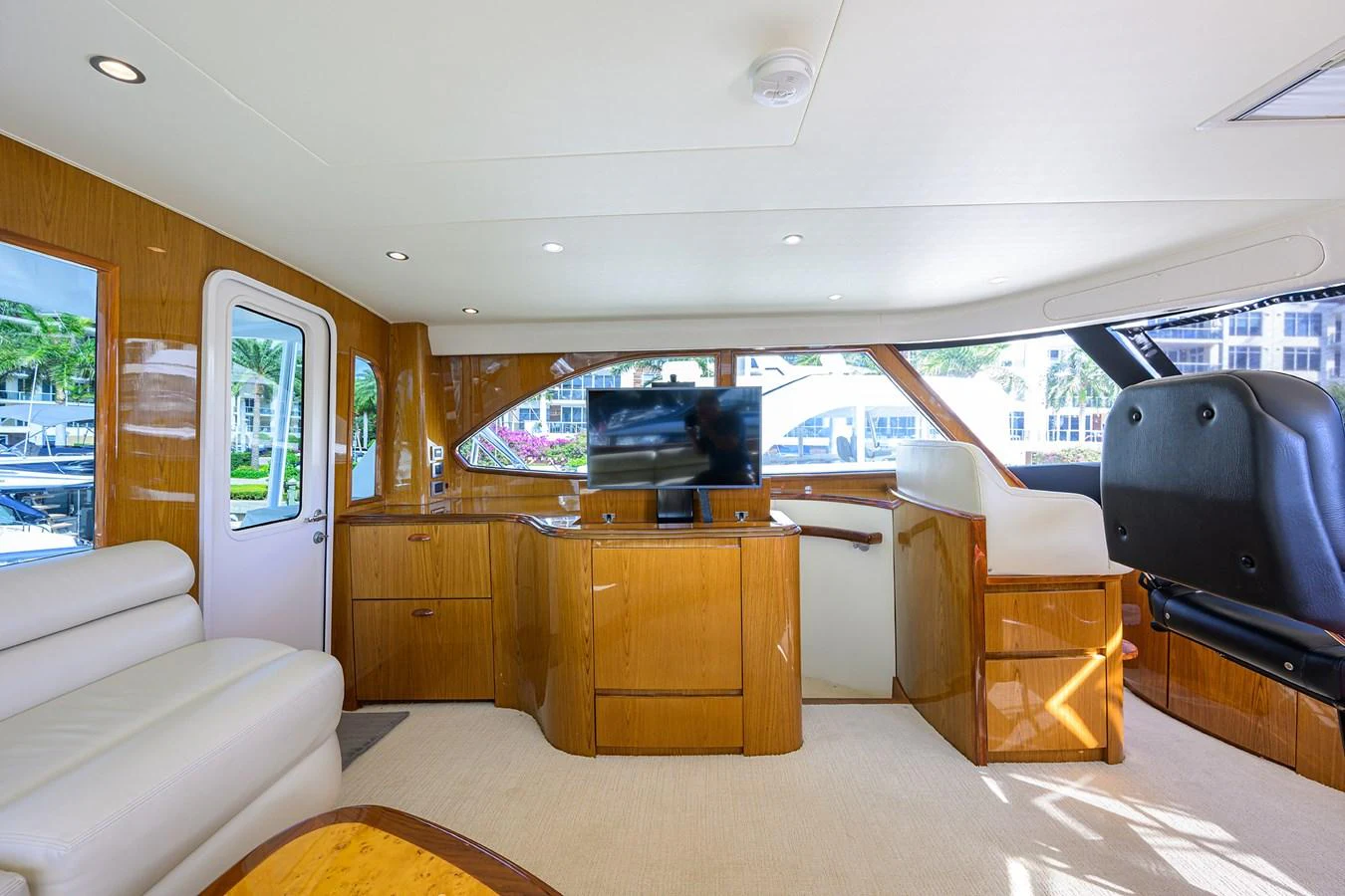 The salon features elegant wood finishes and comfortable seating with a view of the marina. aboard WASABI Yacht for Sale