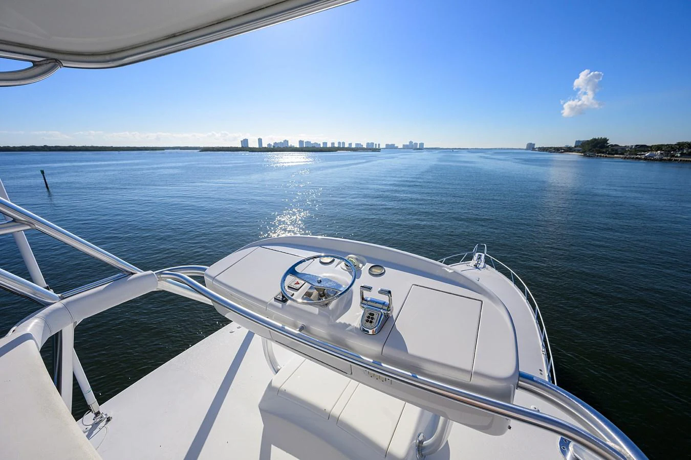 The flybridge offers a stunning panoramic view of the serene waters and distant skyline. aboard WASABI Yacht for Sale
