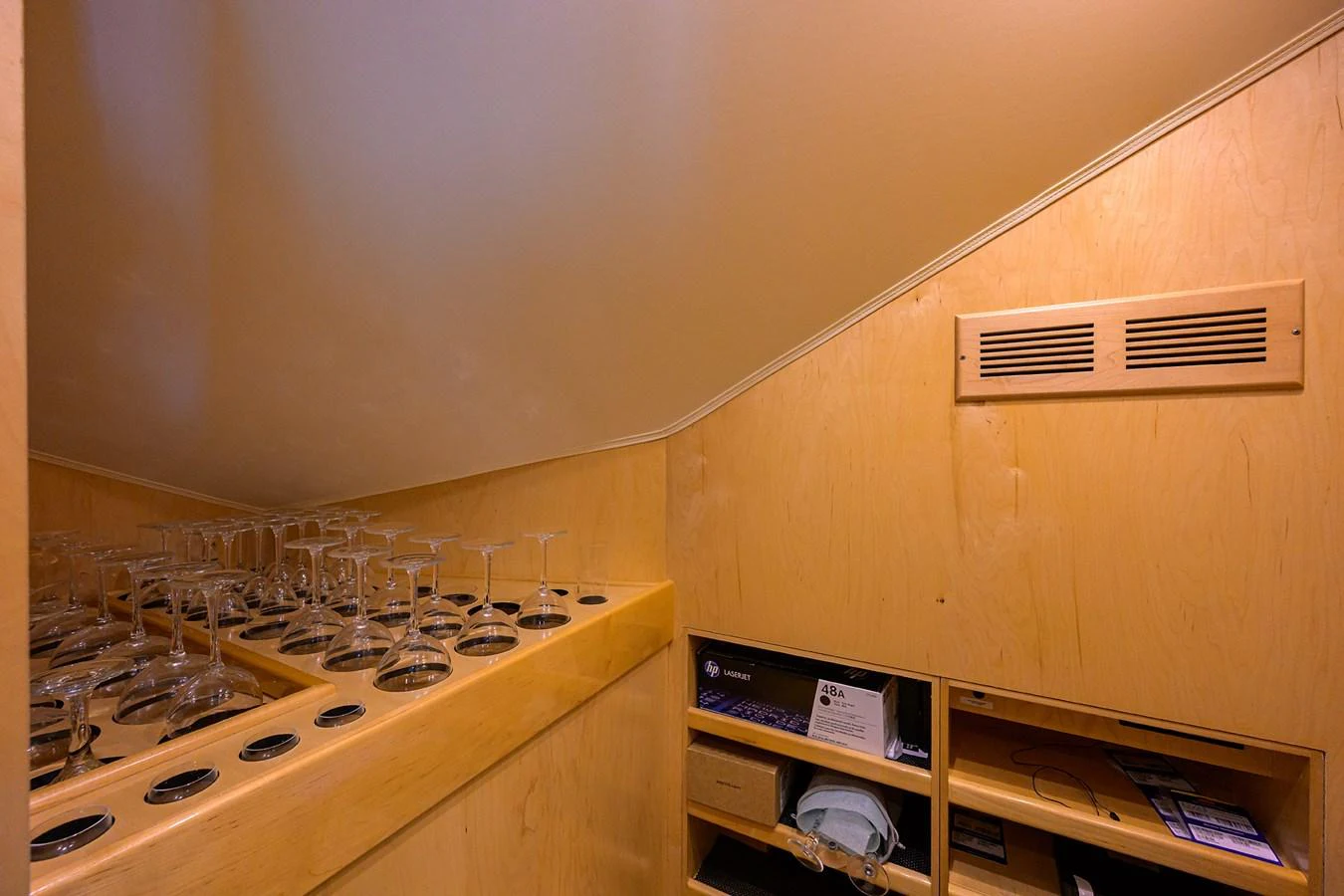 A cozy interior storage area with neatly arranged glassware and shelves. aboard WASABI Yacht for Sale