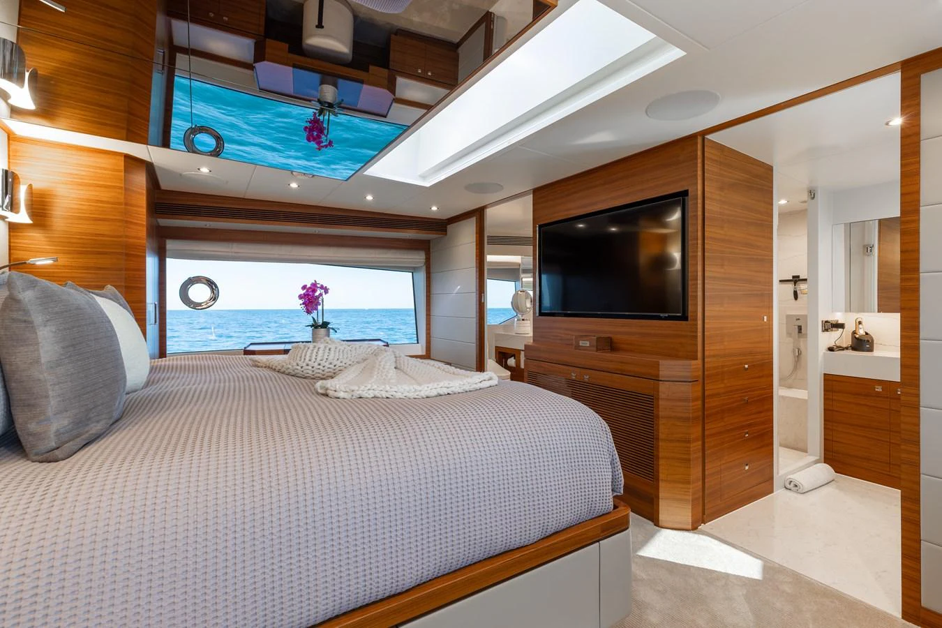 The master stateroom offers a luxurious retreat with a large bed, wood paneling, and a view of the sea. aboard NEX-T Yacht for Sale