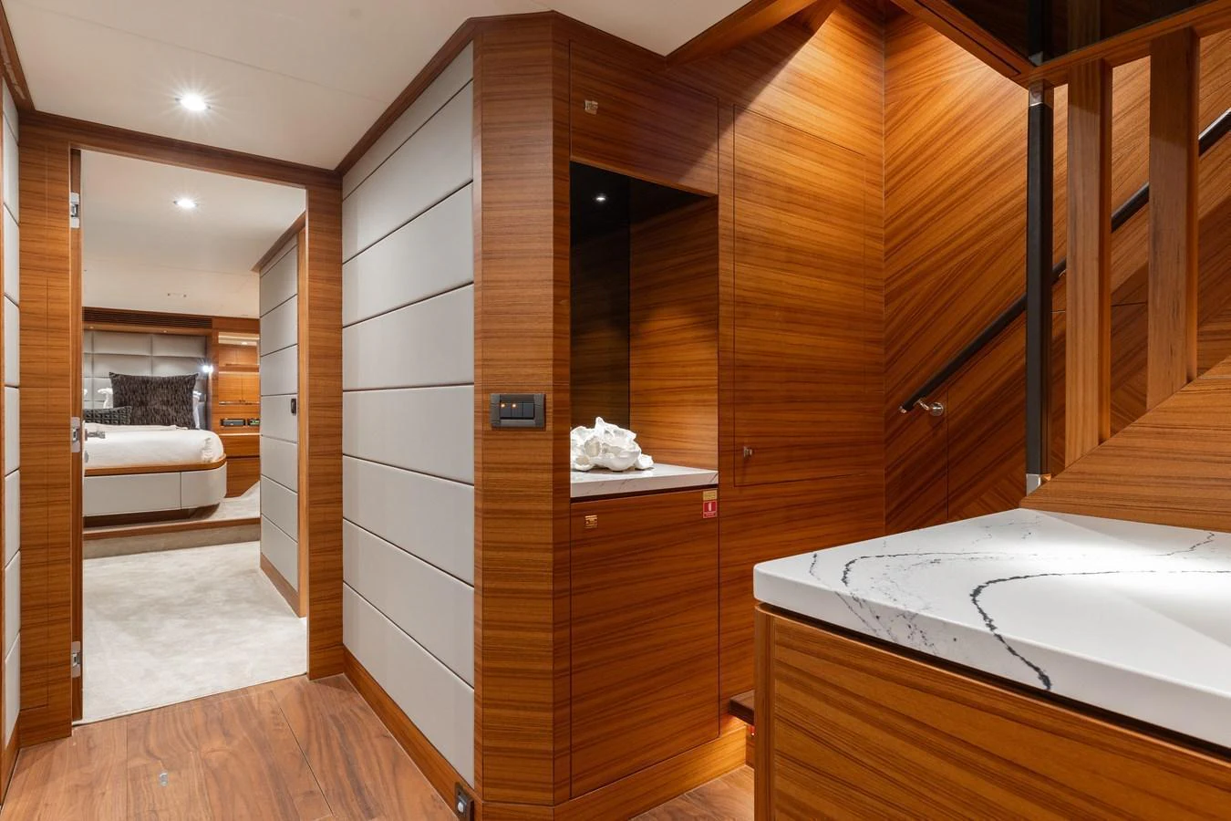 The yacht's interior features a modern hallway with wooden paneling and a view into a cozy stateroom. aboard NEX-T Yacht for Sale