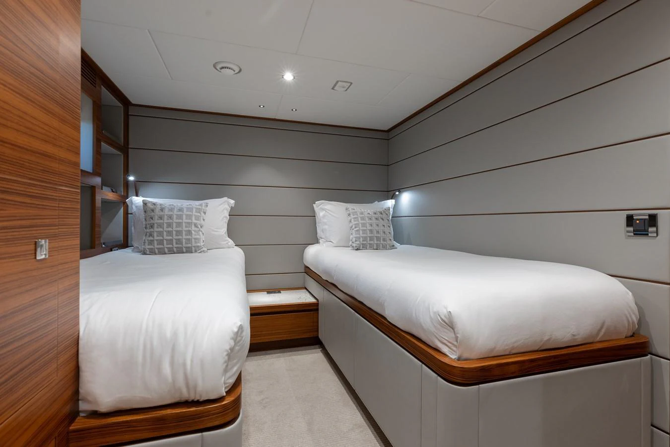 The twin stateroom offers a cozy and elegant sleeping arrangement with two single beds and modern decor. aboard NEX-T Yacht for Sale