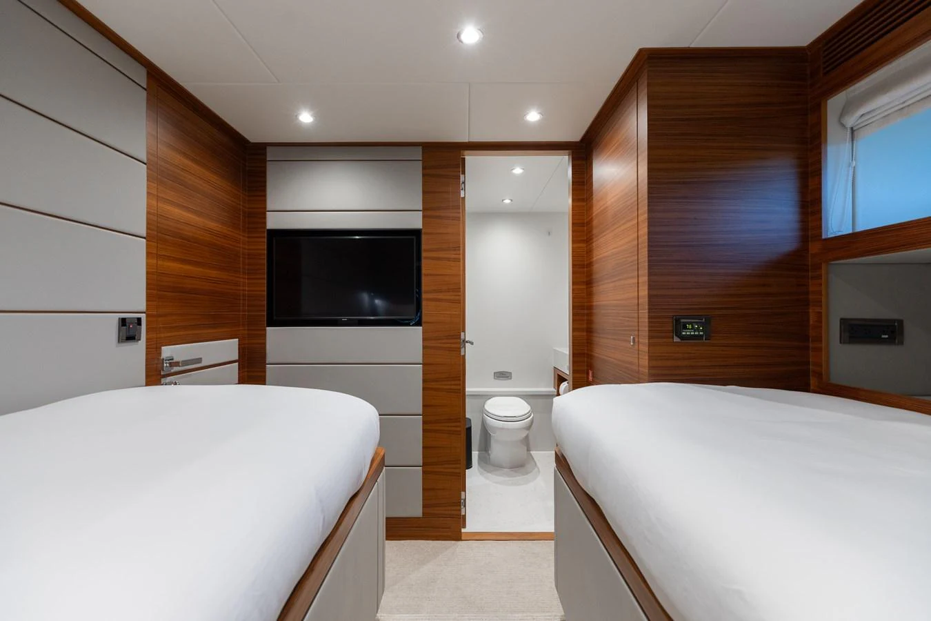 The guest cabin features twin beds, modern wood paneling, and an ensuite bathroom. aboard NEX-T Yacht for Sale