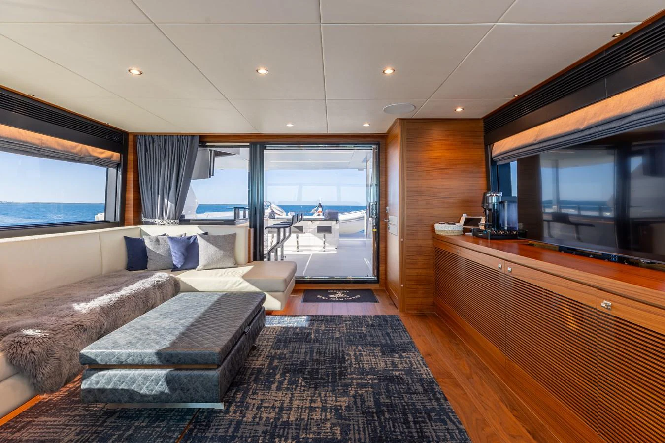 The salon features a spacious seating area with a view of the aft deck and ocean beyond. aboard NEX-T Yacht for Sale