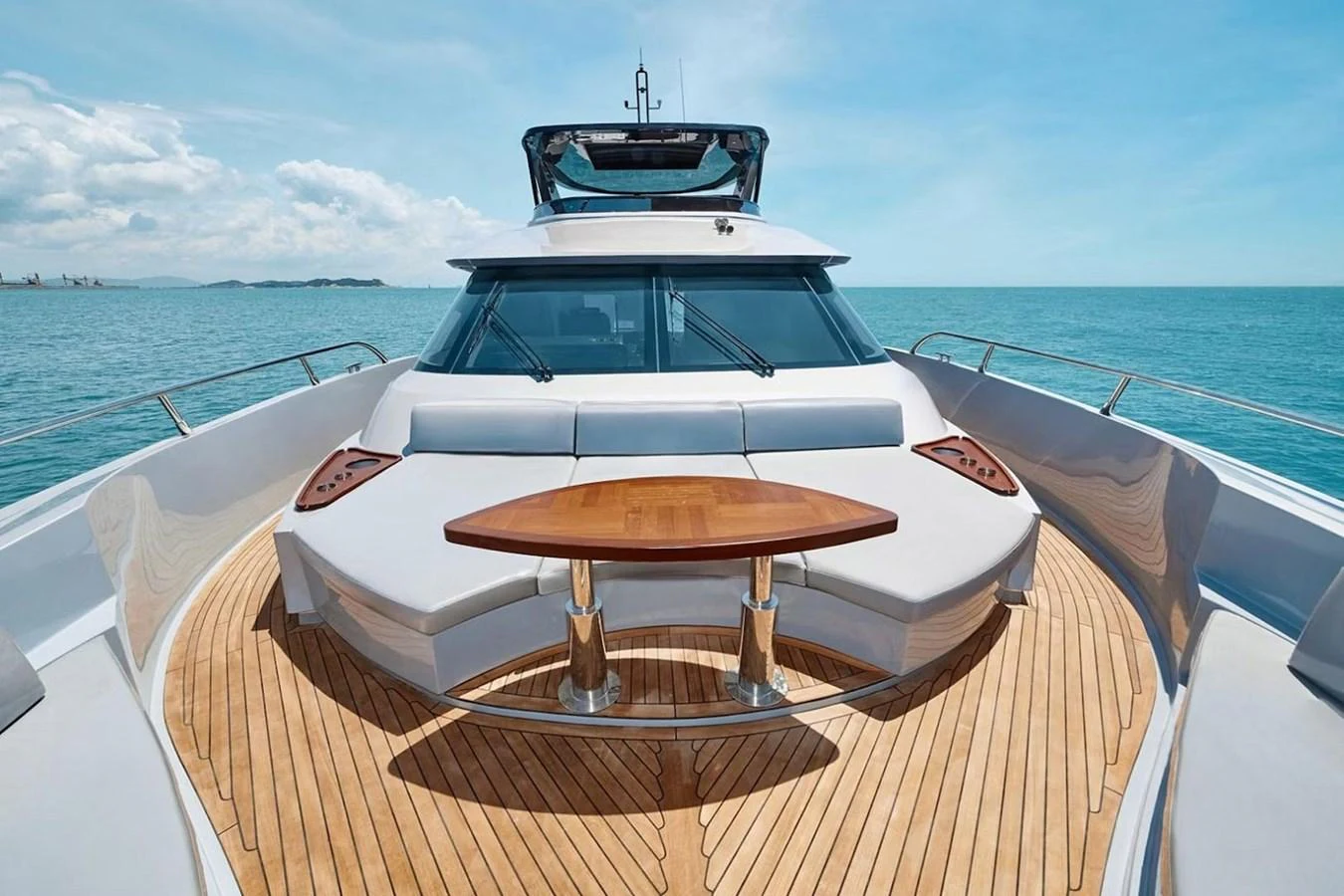The foredeck features a spacious seating area with a wooden table, perfect for enjoying the open sea views. aboard 7809 Yacht for Sale